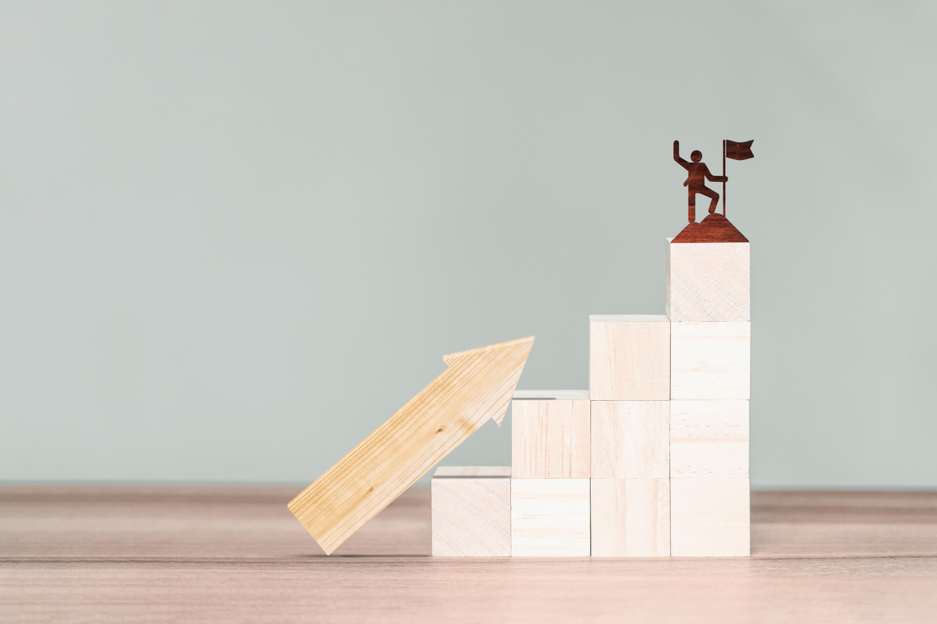 figure raising flag on top of wooden blocks